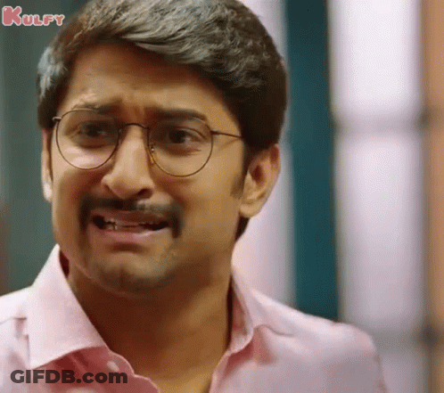 A Man Wearing Glasses And A Pink Shirt Making A Funny Face . GIF