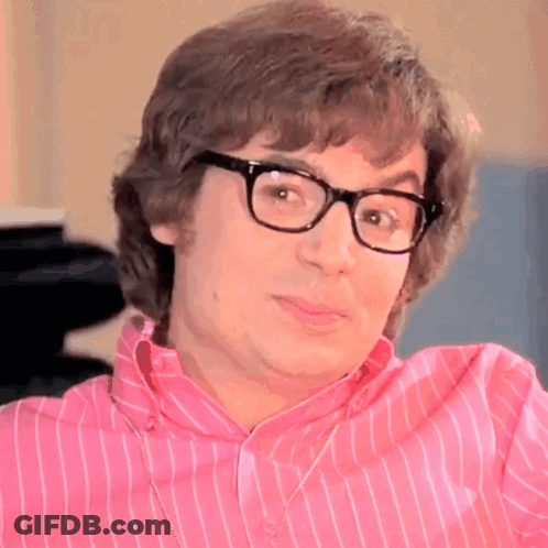 A Man Wearing Glasses And A Pink Striped Shirt Is Making A Funny Face GIF