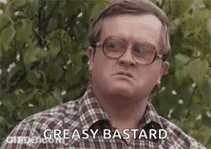 A Man Wearing Glasses And A Plaid Shirt Is Making A Funny Face And Saying `` Greasy Bastard '' . GIF