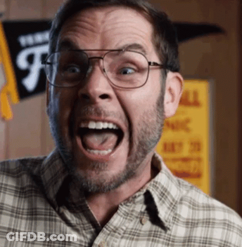 A Man Wearing Glasses And A Plaid Shirt Is Making A Funny Face With His Mouth Open GIF