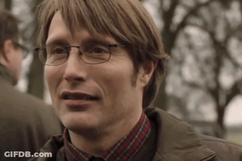 A Man Wearing Glasses And A Plaid Shirt Is Smiling And Making A Funny Face . GIF