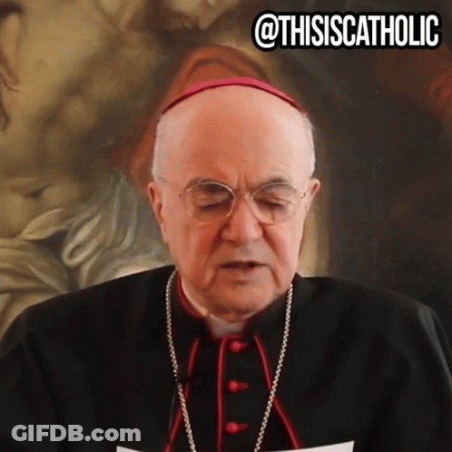 A Man Wearing Glasses And A Purple Hat Stands In Front Of A Painting With The Caption " @Thisiscatholic " GIF