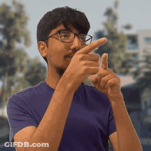 A Man Wearing Glasses And A Purple Shirt Is Pointing His Finger At Something GIF