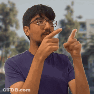 A Man Wearing Glasses And A Purple Shirt Is Pointing GIF