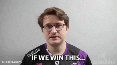 A Man Wearing Glasses And A Purple Shirt Is Standing In Front Of A White Wall . GIF