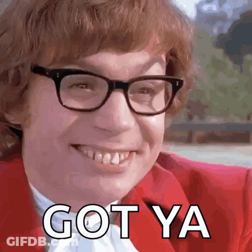 A Man Wearing Glasses And A Red Jacket Is Smiling And Saying Got Ya GIF