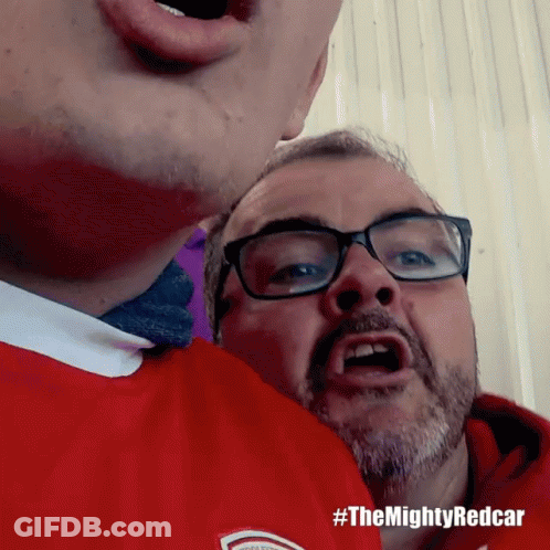 A Man Wearing Glasses And A Red Shirt Has #Themightyredcar Written On The Bottom GIF
