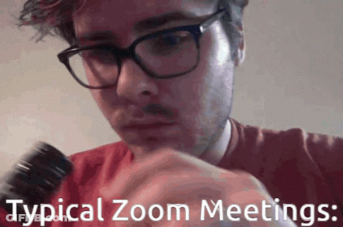 A Man Wearing Glasses And A Red Shirt Is Holding A Microphone With The Words Typical Zoom Meetings Below Him GIF