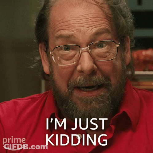 A Man Wearing Glasses And A Red Shirt Says " I 'M Just Kidding " GIF