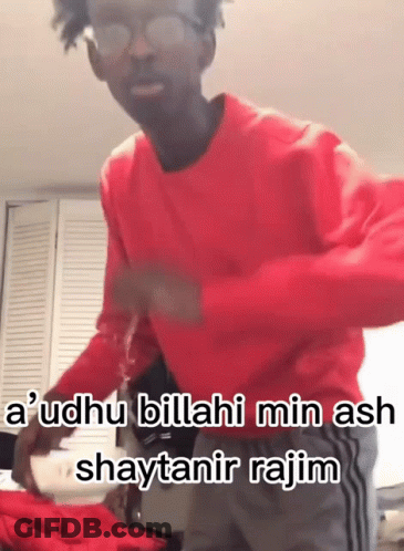 A Man Wearing Glasses And A Red Sweater Says " A ' Udhu Billahi Min Ash " GIF