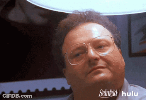 A Man Wearing Glasses And A Shirt That Says Seinfeld On The Bottom GIF