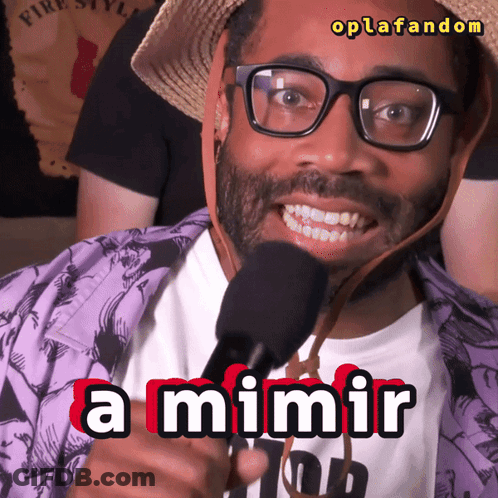 A Man Wearing Glasses And A Straw Hat Is Holding A Microphone And Says A Mimir GIF
