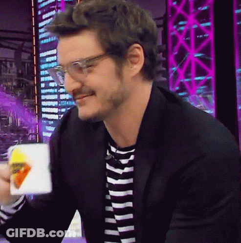 A Man Wearing Glasses And A Striped Shirt Is Smiling While Holding A Bag Of Chips GIF