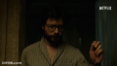 A Man Wearing Glasses And A Striped Shirt Is Standing In A Dark Room With Netflix Written On The Bottom GIF