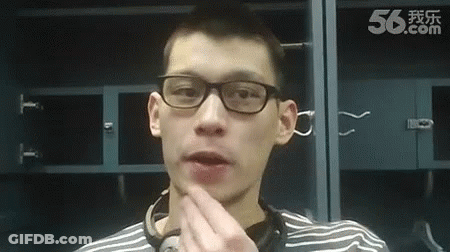 A Man Wearing Glasses And A Striped Shirt Is Standing In Front Of A Locker Room . GIF