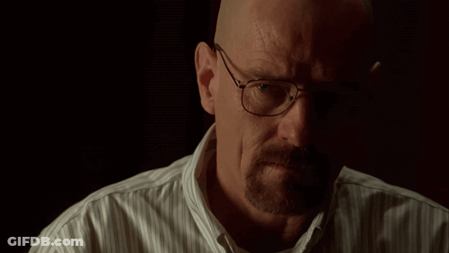 A Man Wearing Glasses And A Striped Shirt Looks At The Camera GIF