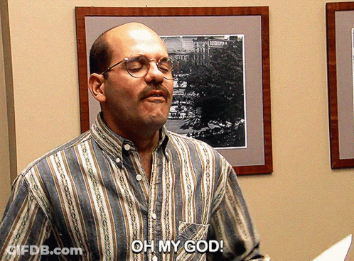 A Man Wearing Glasses And A Striped Shirt Says " Oh My God " GIF