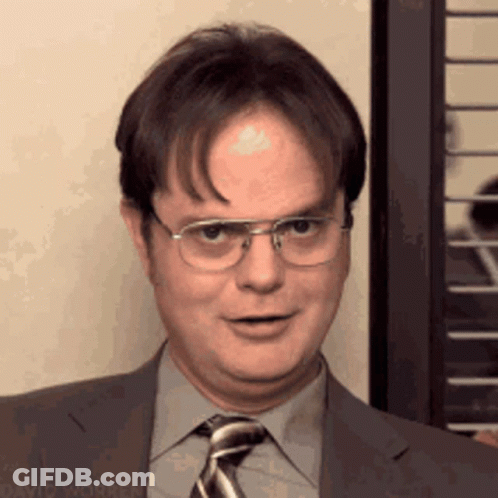 A Man Wearing Glasses And A Suit And Tie Is Smiling GIF