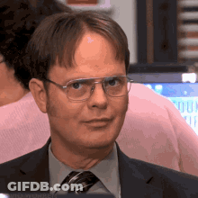 A Man Wearing Glasses And A Suit And Tie Looks At The Camera GIF