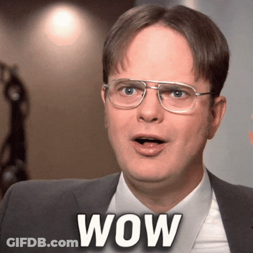 A Man Wearing Glasses And A Suit Has The Word Wow On His Chest GIF