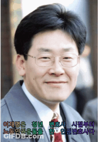 A Man Wearing Glasses And A Suit Is Smiling In A Picture With Asian Writing GIF