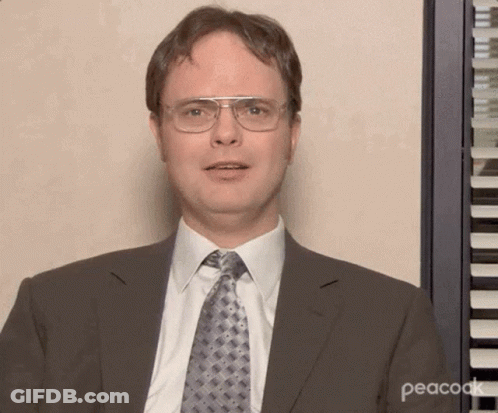 A Man Wearing Glasses And A Suit Is Standing In Front Of A Piano Keyboard . GIF