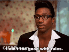 A Man Wearing Glasses And A Suit Is Talking About Rules . GIF