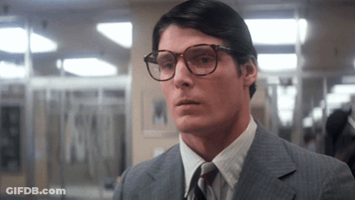 A Man Wearing Glasses And A Suit Looks To The Side GIF