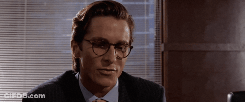 A Man Wearing Glasses And A Suit Looks To The Side GIF