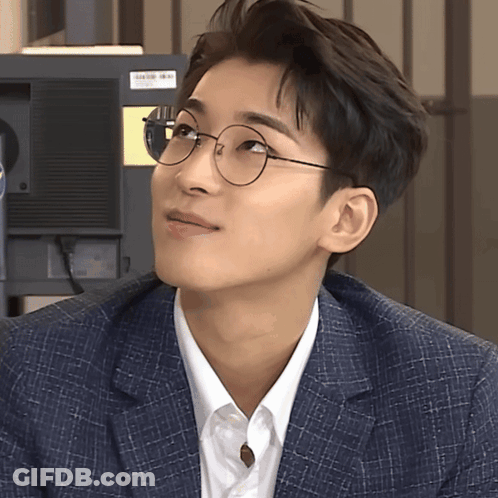 A Man Wearing Glasses And A Suit Looks Up GIF