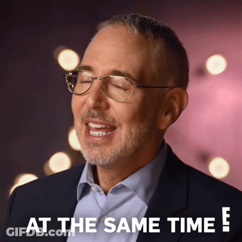A Man Wearing Glasses And A Suit Says " At The Same Time " GIF