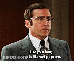 A Man Wearing Glasses And A Suit Says I Like Your Hair It Looks Like Wet Popcorn GIF