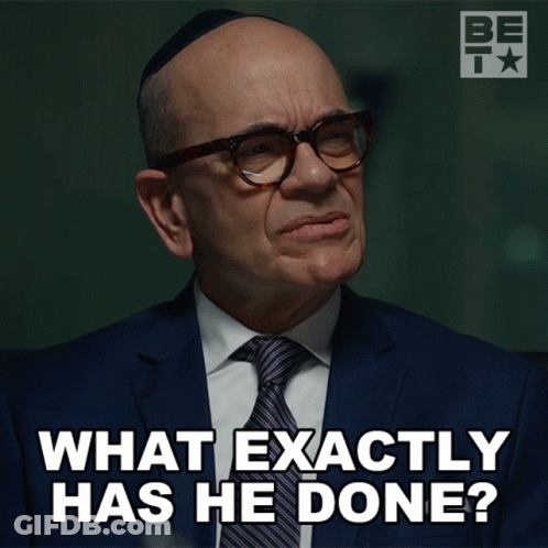 A Man Wearing Glasses And A Suit Says What Exactly Has He Done GIF