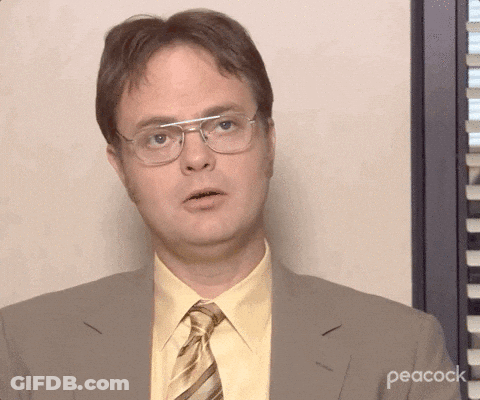 A Man Wearing Glasses And A Suit With Peacock Written On The Bottom Right GIF