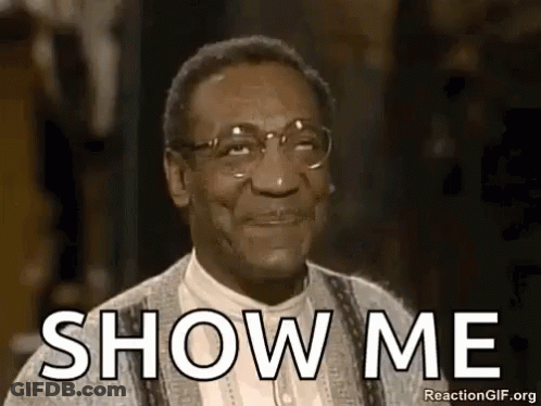 A Man Wearing Glasses And A Sweater Is Smiling And Saying `` Show Me '' . GIF