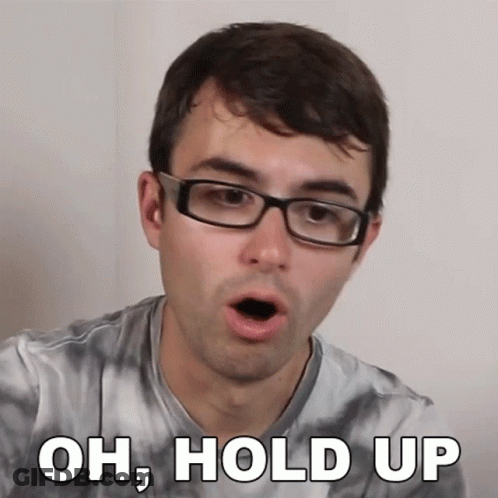 A Man Wearing Glasses And A Tie Dye Shirt Is Saying Oh Hold Up GIF