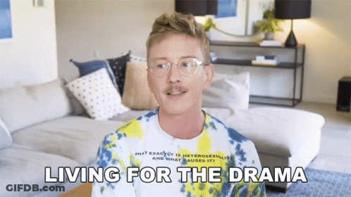 A Man Wearing Glasses And A Tie Dye Shirt Is Talking About Living For The Drama GIF