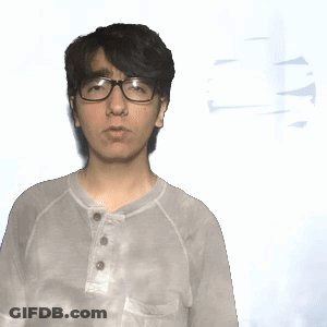 A Man Wearing Glasses And A Tie Dye Shirt Stands In Front Of A White Background GIF