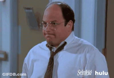 A Man Wearing Glasses And A Tie Has A Seinfeld Hulu Advertisement Behind Him GIF
