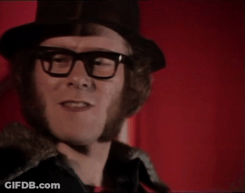 A Man Wearing Glasses And A Top Hat Says Is It GIF