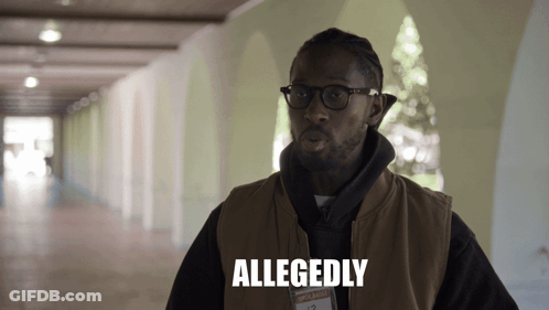 A Man Wearing Glasses And A Vest Has Allegedly Written On His Chest GIF