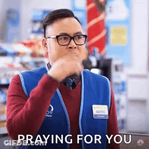 A Man Wearing Glasses And A Vest Is Praying For You . GIF