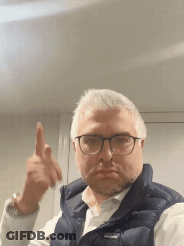 A Man Wearing Glasses And A Vest That Says Patagonia GIF