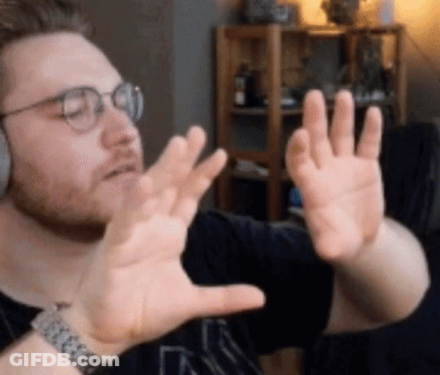 A Man Wearing Glasses And A Watch Is Making A Funny Face With His Hands GIF
