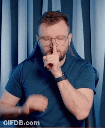 A Man Wearing Glasses And A Watch Is Making A Shhh Gesture GIF