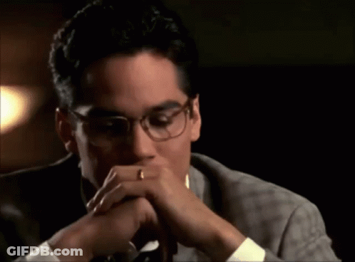 A Man Wearing Glasses And A Wedding Ring Is Covering His Mouth With His Hands . GIF