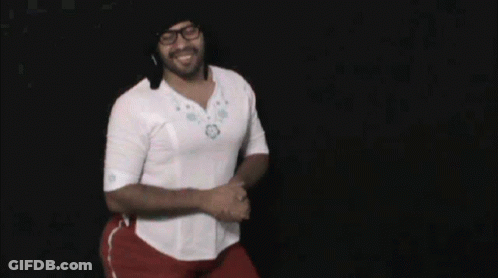A Man Wearing Glasses And A White Shirt Is Dancing In Front Of A Black Background GIF