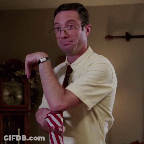 A Man Wearing Glasses And A White Shirt Is Holding A Red And White Striped Shirt GIF