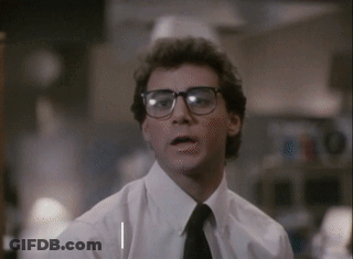 A Man Wearing Glasses And A White Shirt Is Looking At The Camera GIF