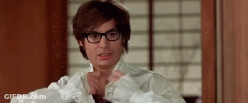 A Man Wearing Glasses And A White Shirt Is Standing In Front Of A Window . GIF